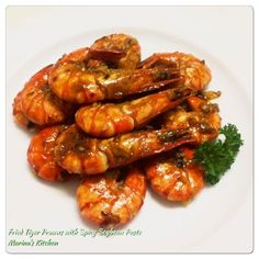 grilled shrimp on a white plate with parsley