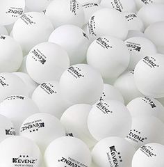 many white ping pong balls are in a large pile with black lettering on them