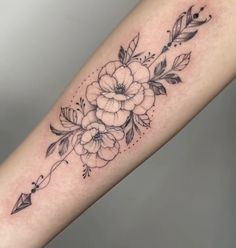 a black and white flower tattoo on the arm