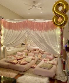 a room decorated in pink and white with balloons