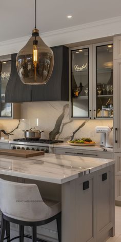 a kitchen with marble counter tops and stools next to an island in the middle