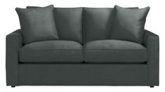 a gray couch with four pillows on it's back and one arm facing the camera