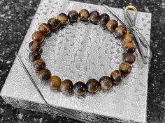 This piece is a unisex stretch bracelet. It is handcrafted and double strung with clear stretch magic cord for extra strength. Made with 8mm Natural Brown Tigers Eye Beads. Perfect for any occasion! Male or female! A bracelet of 6.5-7 inches is the most common in women's jewelry. Keep in mind that they will stretch over the wrist and so should fit a range of wrist sizes up to about 8 inches A bracelet of 7.5-8 inches is the most common in men's bracelets. Keep in mind that they will stretch over the wrist and so should fit a range of wrist sizes up to about 9 inches.  Choose your size from the drop down menu. As a general rule, add 1/2 - 3/4 inch to your wrist measurement for a loose fit A stone of protection, Tiger Eye may also bring good luck to the wearer. It has the power to focus the Brown Hand Wrapped Stretch Bracelet Gift, Spiritual Stretch Bracelet With Spacer Beads Gift, Brown Hand Wrapped Stretch Bracelet For Gift, Flexible Stretch Bracelet With Spacer Beads As Gift, Hand Wrapped Spiritual Stretch Bracelet, Spiritual Stretch Bracelet With Hypoallergenic Round Beads, Flexible Hypoallergenic Stretch Bracelet As A Gift, Hypoallergenic Stretch Bracelet For Meditation, Flexible Jewelry With 8mm Beads As Gift