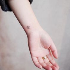 a small four leaf clover tattoo on the left inner wrist and right hand is shown