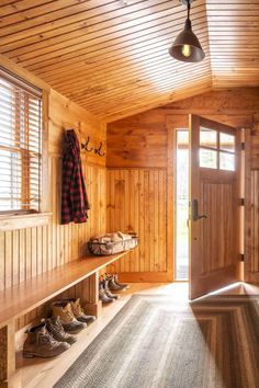 a wooden entryway with shoes on the bench