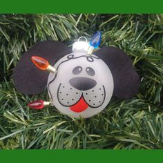 a mickey mouse ornament hanging from a christmas tree with lights on it's ears