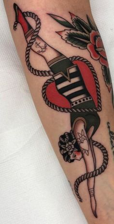 a person with a tattoo on their leg that has an anchor and rope around it