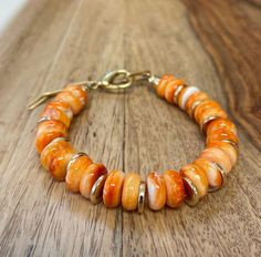 "* Welcome to FoxSparrowOOAKDesign! * This listing is for an orange spiny oyster bracelet handcrafted by me in my smoke free home studio.      * 10mm premium orange spiny oyster beads.  * Gold spacers in between each bead allow the bracelet to lay nicely.      * A gift from the ocean! *  Perfect for a beach vacation or for anyone who loves the ocean. * Measures 6.25\" circumference on the sizing cone but will extend a little longer. * Secured by a strong lobster clasp.    * Ready to ship and sec Luxury Orange Beaded Bracelets, Cheap Orange Beaded Bracelets For Beach, Silk Gifts, Sunset Orange, Hippie Bracelets, Oyster Bracelet, Spiny Oyster, Pearl Shell, Support Handmade