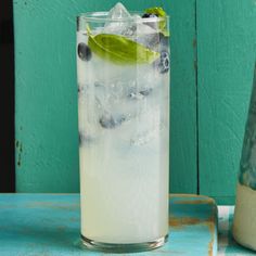 a tall glass filled with ice and blueberries