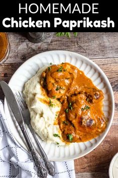 a white plate topped with mashed potatoes covered in chicken parmesan sauce and garnished with parsley