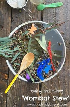 a bowl filled with plants and spoons on top of a wooden table