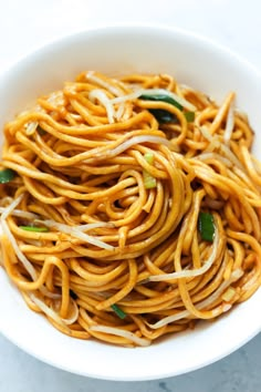 a white bowl filled with noodles and vegetables