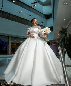 a woman in a white wedding dress holding flowers