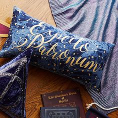 a purple pillow with gold lettering on it next to a passport and some other items