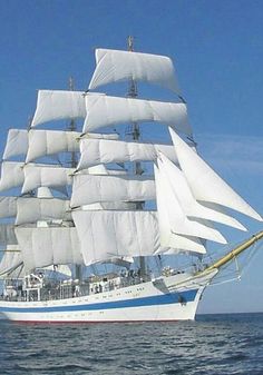 a large white sail boat sailing in the ocean