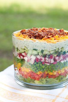 a layered salad in a glass dish on a table