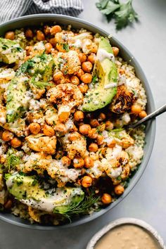 a bowl filled with chickpeas and avocado on top of couscous