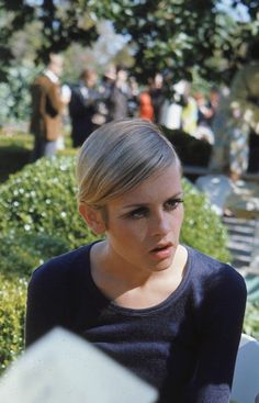 a woman is sitting on a bench in the park and looking at something to her left