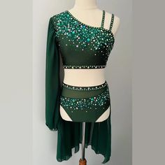 a green and white dress on a mannequin with beadings in the back