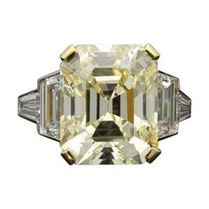 A magnificent emerald-cut diamond ring by Hancocks, the ring centred on a beautiful vintage-cut diamond weighing 8.73cts and of warm yellow tint with VS2 clarity, corner claw set between trapezoid and tapered baguette white diamond shoulders weighing 1.80cts in total, the stones rub over set to accentuate their geometric shapes, all in platinum to a square section band with engraved edging. Maker Hancocks Period Contemporary Origin London Gemstones 8.73ct Y-Z VS2 vintage emerald cut diamond with Emerald Cut Diamond Ring, Yellow Diamond Rings, Jewels Rings, Warm Yellow, Emerald Cut Diamond, Fancy Color Diamonds, Emerald Cut Diamonds, Yellow Diamond, Jewelry Rings Engagement