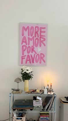 a table with some books on it and a vase full of flowers in the corner