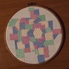 a cross stitch pattern on a wooden surface