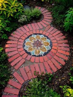 a garden path made out of red bricks with a flower design on the center and side