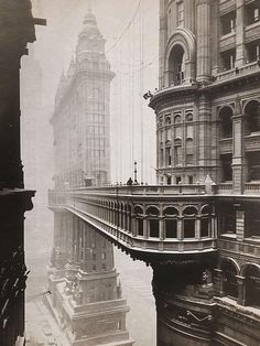 an old black and white photo of people on a bridge over a river in the city