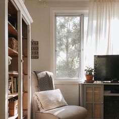 a living room filled with furniture and a flat screen tv sitting on top of a wooden shelf