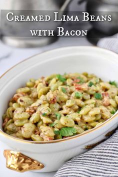 a white bowl filled with macaroni salad on top of a blue and white towel