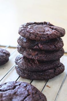 a stack of chocolate cookies sitting on top of a cooling rack next to each other