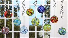 an assortment of glass ornaments hanging in front of a window