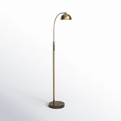 a floor lamp with a marble base and a brass colored metal shade on the top