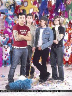 a group of men standing next to each other in front of a wall covered with decorations