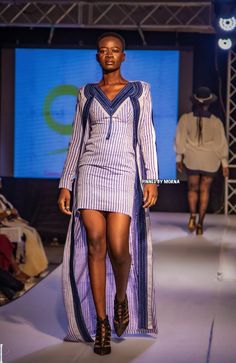 a model walks down the runway in a striped dress