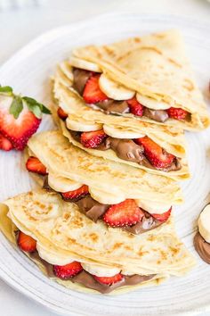 pancakes with chocolate and strawberries on a white plate