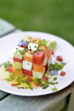 a yellow plate topped with slices of watermelon and other vegtables