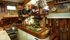 a kitchen filled with lots of cooking utensils and pans hanging from the ceiling