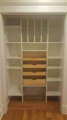 an empty white bookcase with several boxes on it