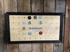 a wooden plaque with the name nathan surrounded by many different types of buttons on it