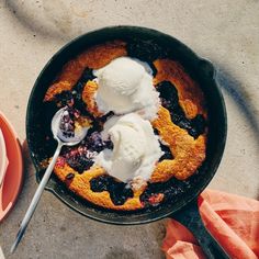 a skillet filled with blueberry cobbler and ice cream