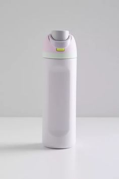 a white plastic bottle with a yellow label on the top and bottom, sitting on a table