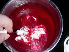 someone mixing red and white food in a bowl