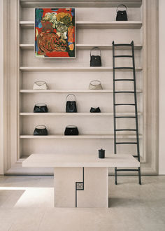 a white shelf filled with lots of purses and handbags next to a ladder