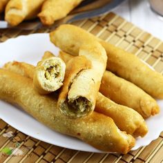 some fried food on a white plate with chopsticks and dipping sauce next to it