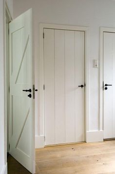 two white doors with black handles in a room