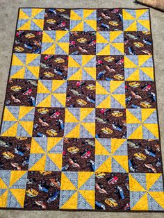 a yellow and blue quilt on the ground