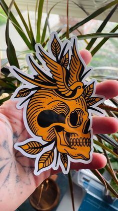 a person holding up a sticker with a skull and bird on it's head