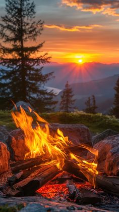 a campfire with the sun setting in the background and some rocks on the ground