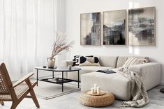 a living room filled with furniture and paintings on the wall next to a coffee table